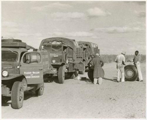 Expedition members changing the tire of the GMC truck (print is a cropped image)