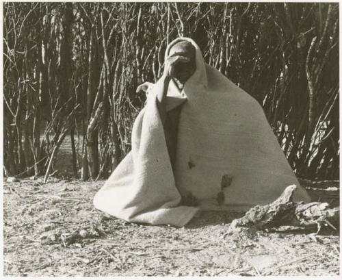 Elderly woman sitting wrapped in a kaross (print is a cropped image)