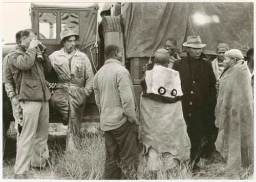 Wilhelm Camm talking to a group of men beside the truck (print is a cropped image)