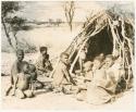 Group sitting in front of a grass hut at Kungwane (print is a cropped image)