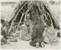 Group of women sitting before a skerm talking to /Gishay while John Marshall takes a picture (print is a cropped image)