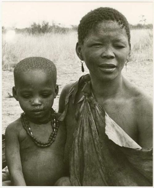 Woman with a child sitting in her lap (print is a cropped image)