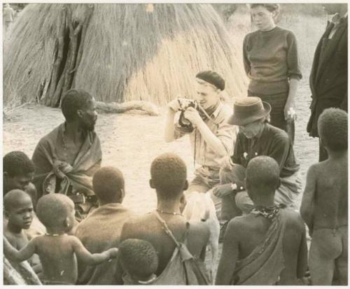 John Marshall photographing a seated group at Kungwane; Elizabeth Marshall Thomas and Lorna Marshall next to him (print is a cropped image)