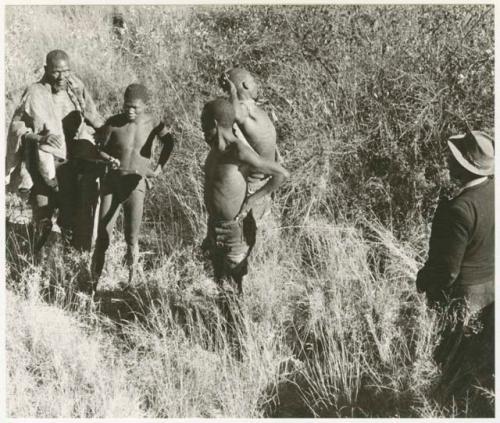 Elderly blind man led by a boy using a long stick (print is a cropped image)