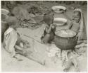 Three seated children beside a cooking pot at Chukudu (print is a cropped image)