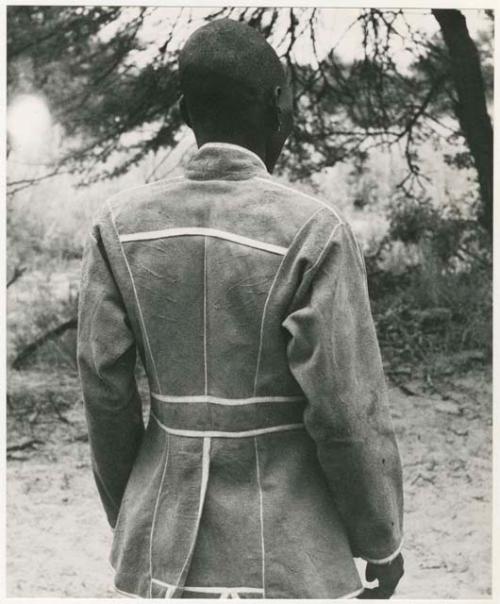 Boy in a tailored leather coat, back view (print is a cropped image)