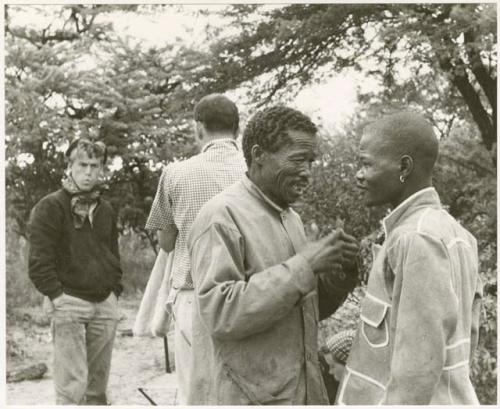 /Gishay talking to the boy in the tailored coat; John Marshall and William Donnellan in the background (print is a cropped image)