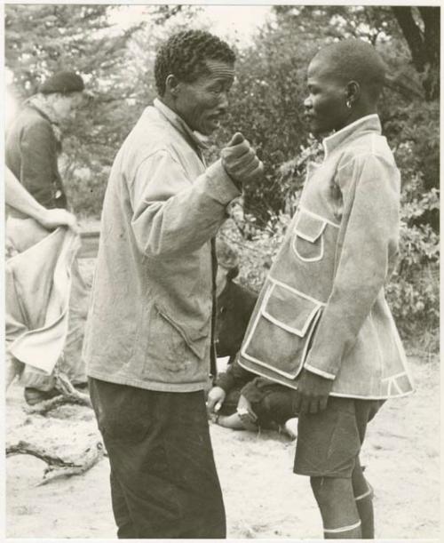 /Gishay talking to boat in the tailored leather coat; John Marshall and Bill Donnellan in the background (print is a cropped image)