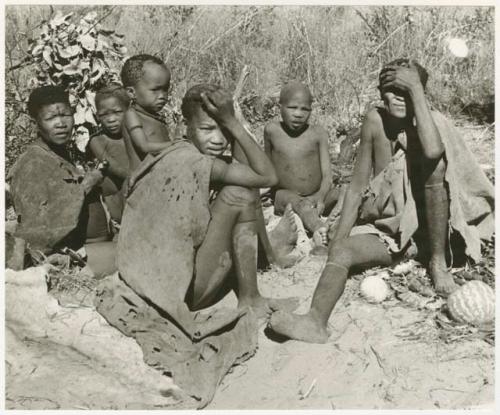 Dasi!na, /Gaiamakwe, N!whakwe, Tsekue, !Oukabe, and another person sitting (print is a cropped image)