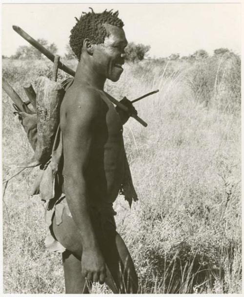 Man carrying a stick on his shoulder and on his back (print is a cropped image)