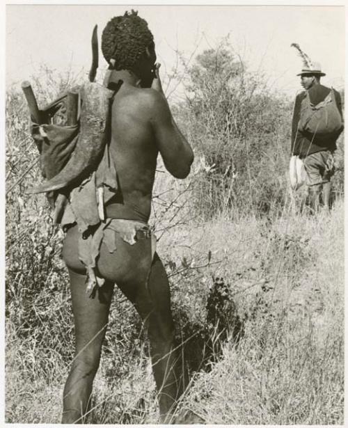 Man carrying sticks and the man wearing a hat with a feather (print is a cropped image)