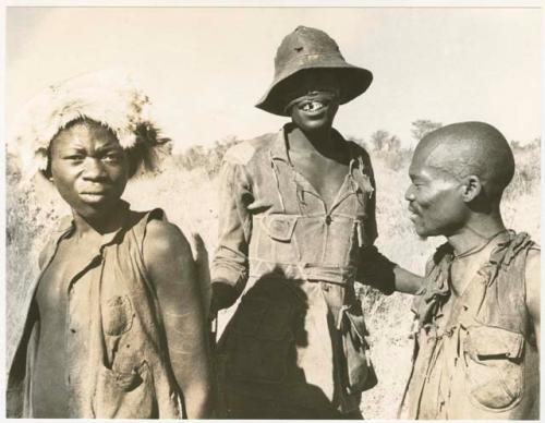 Headman wearing a hat, standing with two other men (print is a cropped image)