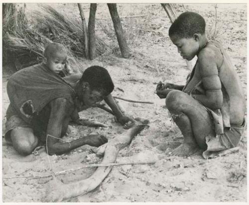 Rukan sitting across from Genitsu, who is crouched forward with a baby on her back (print is a cropped image)