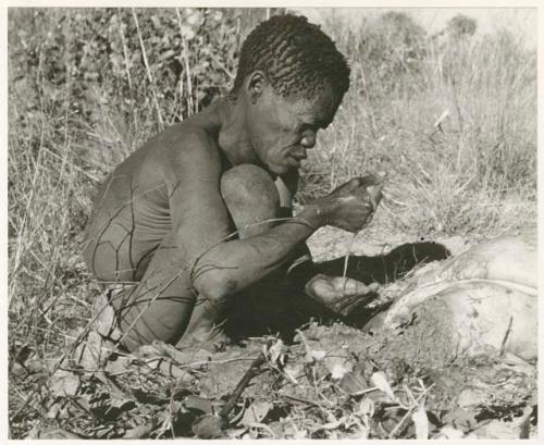 Oukwane squeezing liquid into his hand (print is a cropped image)