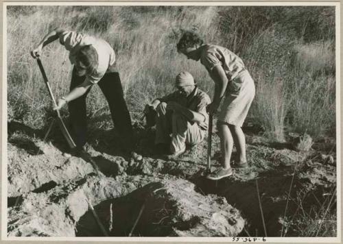 Elizabeth Marshall Thomas and John Marshall digging; another expedition member sitting