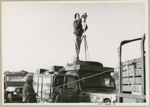 John Marshall with a camera on tripod, on top of expedition truck