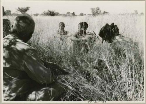 !Gai and Oukwane sitting in the grass with Laurence Marshall and Lorna Marshall