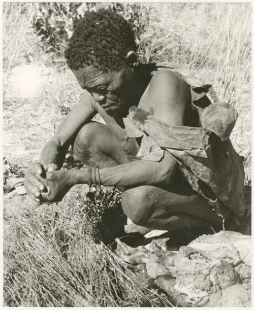 Oukwane squeezing the stomach contents of the gemsbok using grass sieve, close-up (print is a cropped image)