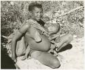 Tsekue sitting and N!whakwe nursing (print is a cropped image)