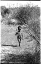 Boy walking, holding a stick