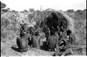 Group of Ju/'hoansi telling stories including "Lame ≠Gao" seen from behind, ≠Gao (Khwo//o's-/Gasa's husband), Gao Medicine, an unidentified person, ≠Toma, !Naishi, "Old Xama" holding a child, "Gao Helmet," "Old Demi" lying down, "Crooked /Qui," Gao (Debe's son, Zuma's husband), ≠Toma (!Naishi's son), and Zuma (Gao's wife)