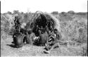 Group of Ju/'hoansi telling stories including "Lame ≠Gao" seen from behind, ≠Gao (Khwo//o's-/Gasa's husband), Gao Medicine, an unidentified person, ≠Toma, !Naishi, "Old Xama" holding a child, "Gao Helmet," "Old Demi" lying down, "Crooked /Qui," Gao (Debe's son, Zuma's husband), ≠Toma (!Naishi's son), and Zuma (Gao's wife)