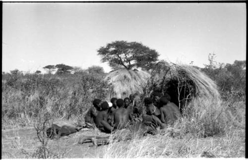 Group of Ju/'hoansi telling stories including "Lame ≠Gao," ≠Gao (Khwo//o-/Gasa's husband), "Gao Medicine," an unidentified person, ≠Toma, !Naishi, "Old Xama," "Gao Helmet," "Old Demi" lying down, Crooked /Qui, Gao (Debe's son, Zuma's husband), and ≠Toma (!Naishi's son)