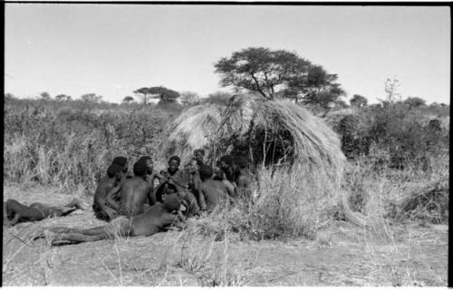 Group of Ju/'hoansi telling stories including "Lame ≠Gao," ≠Gao (Khwo//o-/Gasa's husband), "Gao Medicine," an unidentified person, ≠Toma, !Naishi, "Old Xama," "Gao Helmet," "Old Demi" lying down, Crooked /Qui, Gao (Debe's son, Zuma's husband), and ≠Toma (!Naishi's son)