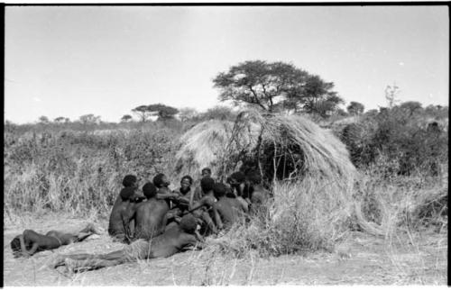 Group of Ju/'hoansi telling stories including "Lame ≠Gao," ≠Gao (Khwo//o-/Gasa's husband), "Gao Medicine," an unidentified person, ≠Toma, !Naishi, "Old Xama," "Gao Helmet," "Old Demi" lying down, Crooked /Qui, Gao (Debe's son, Zuma's husband), and ≠Toma (!Naishi's son)