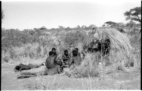 Group of Ju/'hoansi telling stories including "Lame ≠Gao," ≠Gao (Khwo//o-/Gasa's husband), "Gao Medicine," an unidentified person, ≠Toma, !Naishi, "Old Xama," "Gao Helmet," "Old Demi" lying down, Crooked /Qui, Gao (Debe's son, Zuma's husband), and ≠Toma (!Naishi's son)