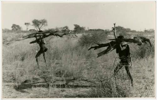 Two men carrying wood