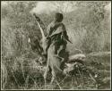 Woman carrying wood, seen from the back