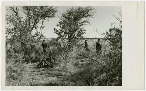 Women and children near bushes