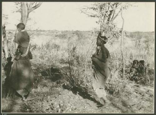 Two women, one with a child on her shoulders, leaving Gautscha