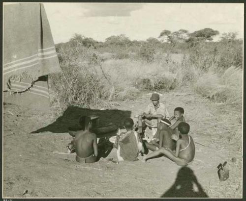 Ngani and unidentified Ju/'hoan boys around a fire