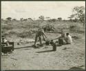 Philip Hameva at the cooking fire and an unidentified man crouching nearby