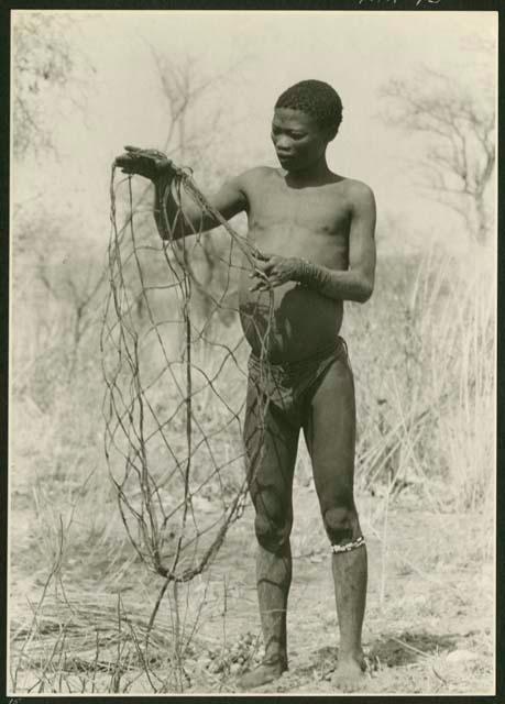 Gao standing and holding a carrying net