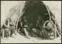 Ju/'hoan children sitting inside a skerm; water bag made from animal stomach hangs from the side of the entrance