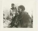 Elderly man and young man sitting (print is a cropped image)