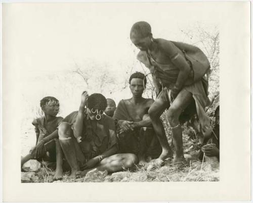 Group of Ju/'hoansi sitting; one woman is half crouching (print is a cropped image)