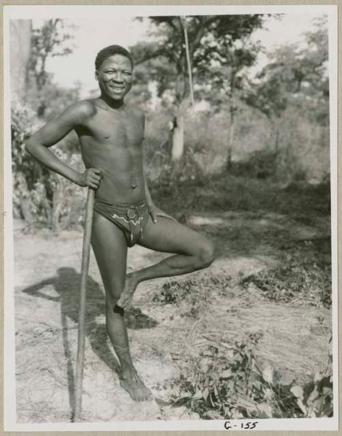 Man standing on one leg leaning against his stick