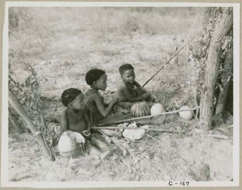 Three children sitting in the werft of the people from the northeast, eating mealies