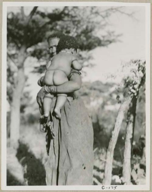 Woman standing and holding a baby (out of focus)