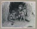 "Gao Helmet" sitting with two of his children in front of his skerm
