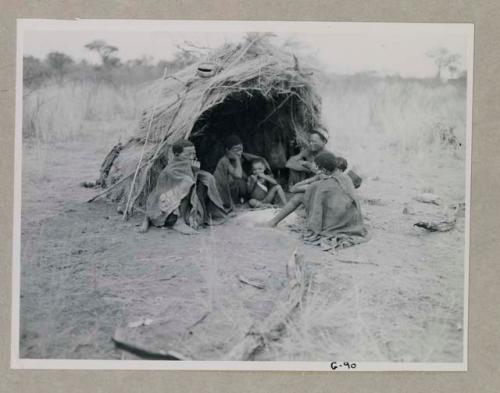 Ti//khao, headman of Band 7, and /Khoa his wife seated in front of a skerm with group
