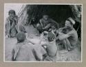 Ti//khao, headman of Band 7, and /Khoa his wife seated in front of a skerm with group