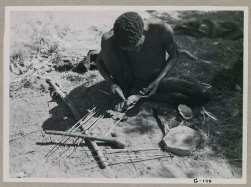 "Gao Medicine" applying poison to the shaft of an arrow with a stick
