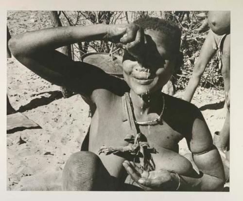 Woman squeezing a handful of pulp from the water root over her face to wash