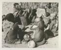 Group at Chukudu sitting; child drinking tsama melon juice
