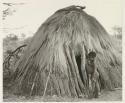 Child standing by the doorway of hut
